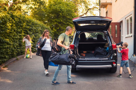 Familie packt ihr Elektroauto um in den Urlaub zu fahren