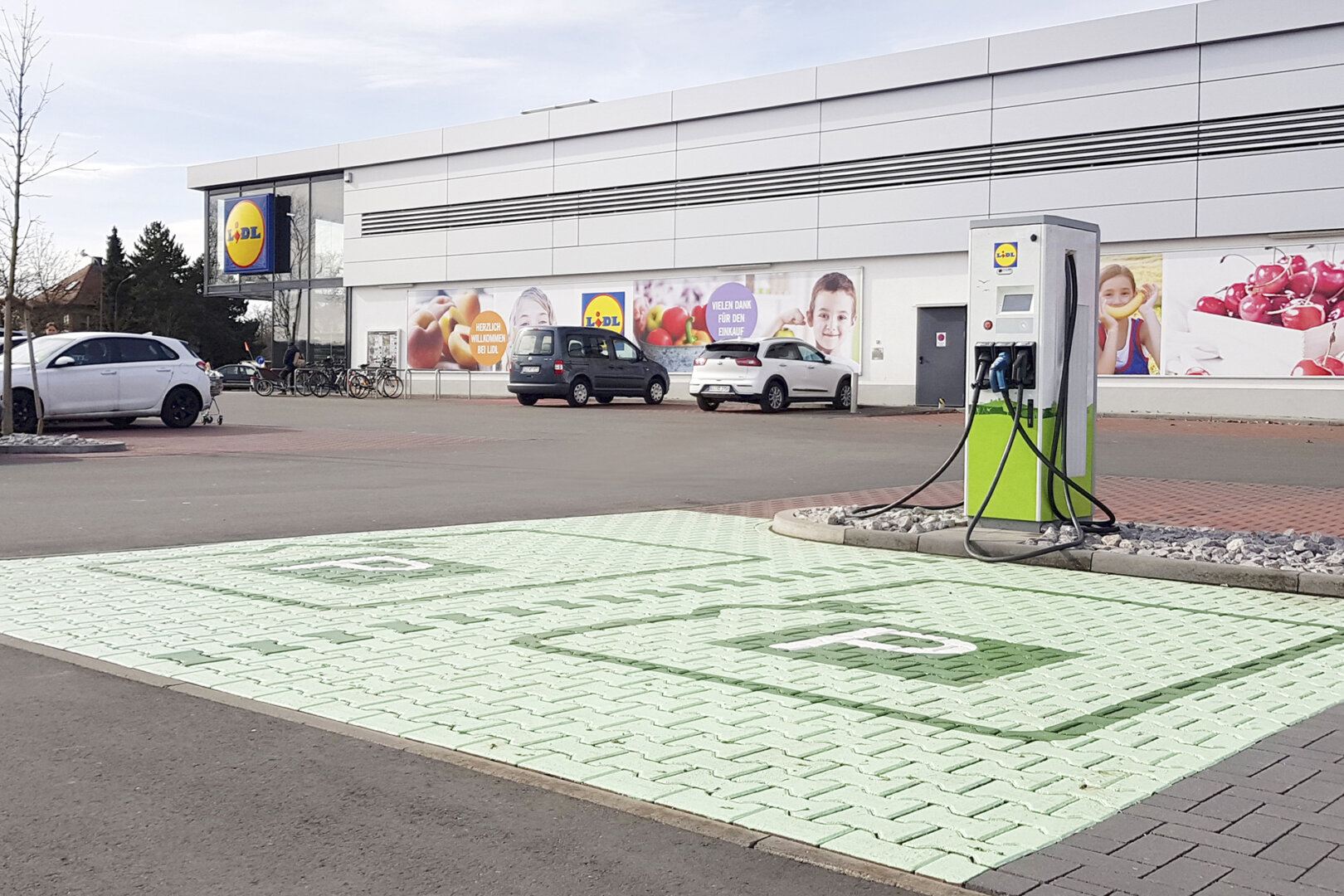 Grüne Ladesäule auf einem Lidl Parkplatz.
